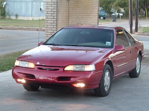1994 Ford Thunderbird - A red 1994 Ford Thunderbird is parked on a driveway.