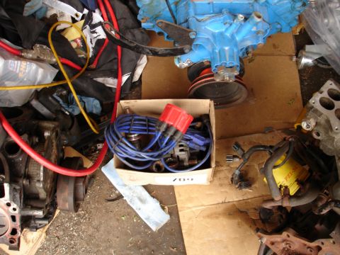 1981 Ford Mustang - Various engine components are laid out on a cardboard surface, suggesting a disassembled engine or parts for repair.