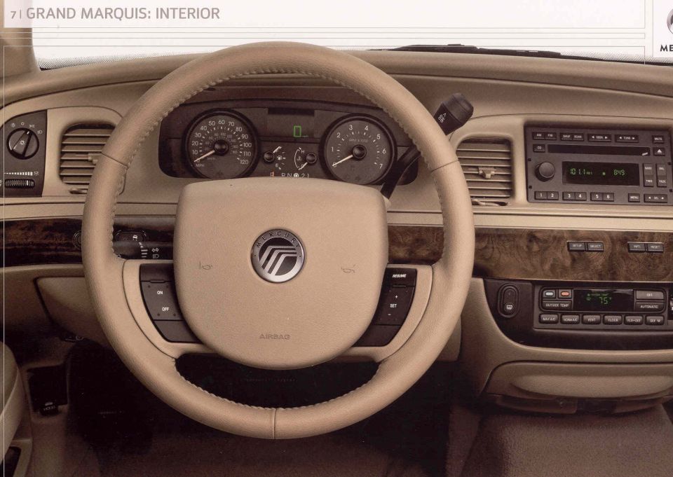 Tan car interior with a leather steering wheel, dashboard, and center console. The Mercury logo is visible on the steering wheel