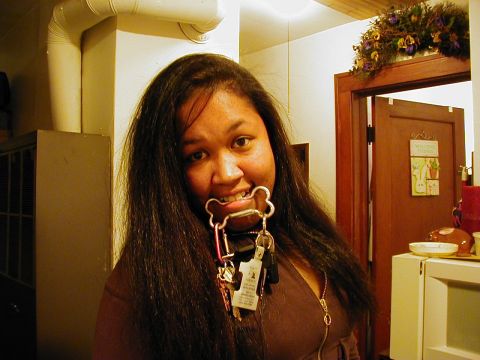 1997 Ford Taurus - A woman playfully holds a set of keys in her mouth, with a doorway and kitchen appliances visible in the background.