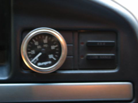 1995 Ford Bronco - Dashboard interior showing a Sunpro gauge and auxiliary buttons.