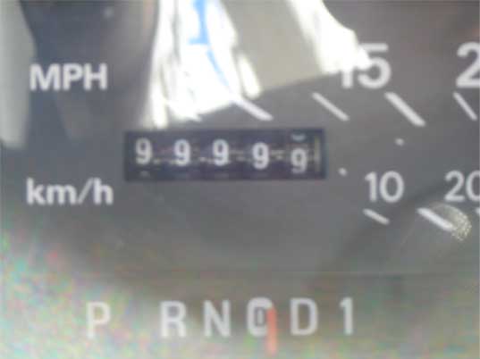 Close-up of a car's dashboard showing the odometer reading 99999 and the gear selector in Park