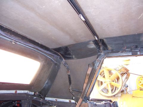 1984 Toyota Celica - The interior roof structure and mechanism of a vehicle are shown, with a yellow fan visible through the window.