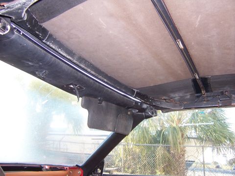 1984 Toyota Celica - The interior of a car shows the headliner and a sun visor, with visible signs of age and use.