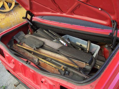 1984 Toyota Celica - Trunk of a 1984 Toyota Celica packed with various interior parts and trim pieces.