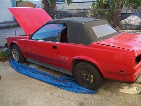 1984 Toyota Celica - This red 1984 Toyota Celica GTS convertible is shown with its hood up, indicating it may be a project or parts car.