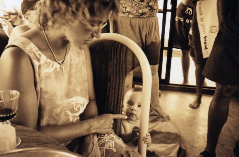 2001 Ford Taurus - A woman points at a baby who is looking at the camera from behind a chair.