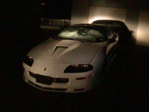 1996 Chevrolet Camaro - Front view of a white 1996 Chevrolet Camaro parked outdoors at night.