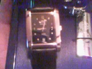1986 Ford Bronco - A close-up view of a square-faced watch with a black band and silver casing.