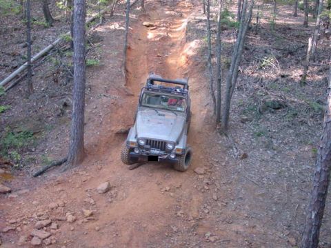 2004 Jeep Wrangler - Jeep TJ navigating a challenging off-road trail through a forest.