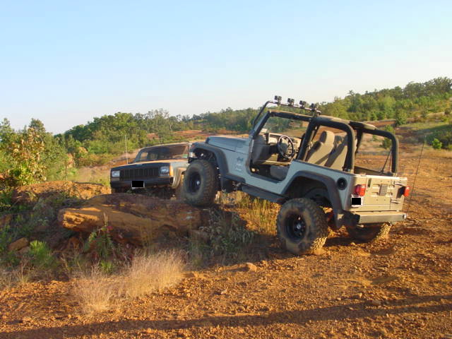 Gray 2004 Jeep TJ and a tan Jeep Cherokee on a dirt hill