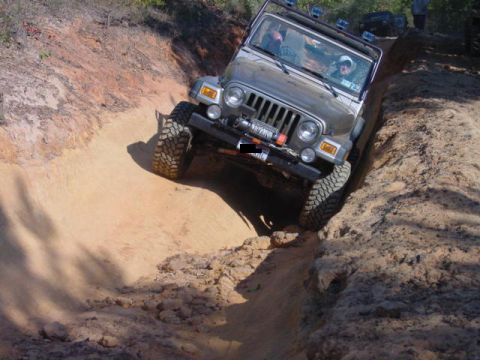 2004 Jeep Wrangler - Jeep TJ tackling a challenging off-road trail with steep inclines and sandy terrain.