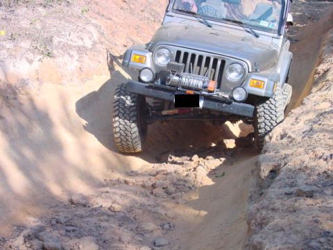 2004 Jeep Wrangler - A Jeep TJ navigates a steep dirt path, its off-road capabilities with a front-mounted winch.