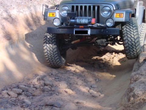 2004 Jeep Wrangler - A Jeep Wrangler navigates a challenging off-road trail, demonstrating its capability.