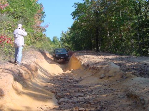 2004 Jeep Wrangler - Jeep TJ tackles an off-road trail with a photographer capturing the action.