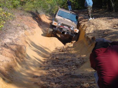 2004 Jeep Wrangler - Jeep TJ tackling a challenging off-road obstacle on a sunny day.