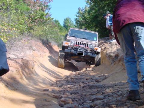 2004 Jeep Wrangler - A Jeep TJ navigates a challenging off-road trail with steep inclines and rocky terrain.