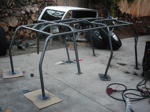 1978 Ford Bronco - A custom roll cage is positioned in front of a white 1978 Ford Bronco.