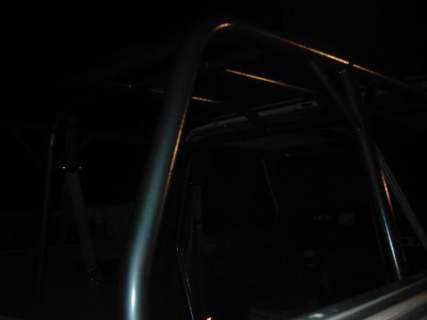 1978 Ford Bronco - The interior of a vehicle is visible, a prominent roll cage structure.