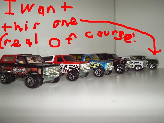 Line of toy trucks with red writing above, one truck is pointed to by a red arrow