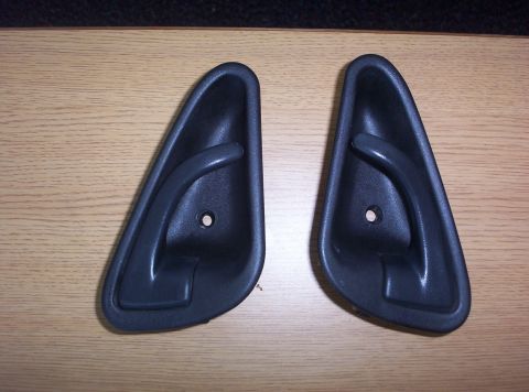 1994 Ford Probe - Two black interior door handles are shown on a wooden surface.