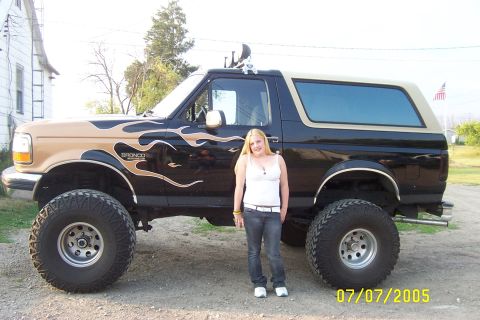 Black and tan lifted Ford Bronco with flame decals and large tires