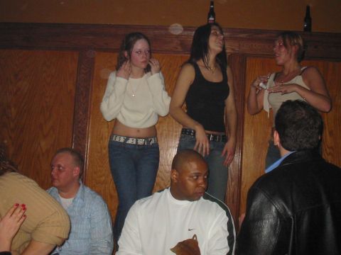 1995 Ford Bronco - A group of people are socializing in a room with wooden walls, with three women standing and two men seated.