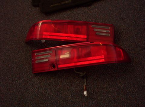 1994 Ford Probe - A pair of red taillights, likely for a car, are shown from a top-down perspective on a dark carpet.
