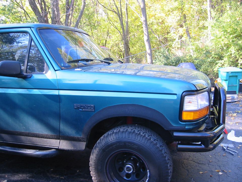Teal Ford Bronco front quarter panel, fender, and bumper with a brush guard. Bronco XL badge visible on fender