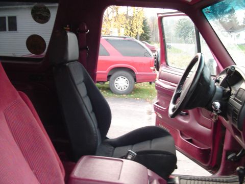 1994 Ford Bronco - Interior view of a 1994 Ford Bronco, with another red SUV parked outside.