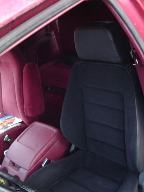 1994 Ford Bronco - The interior of the vehicle features dark gray seats with a red trim and a center console.