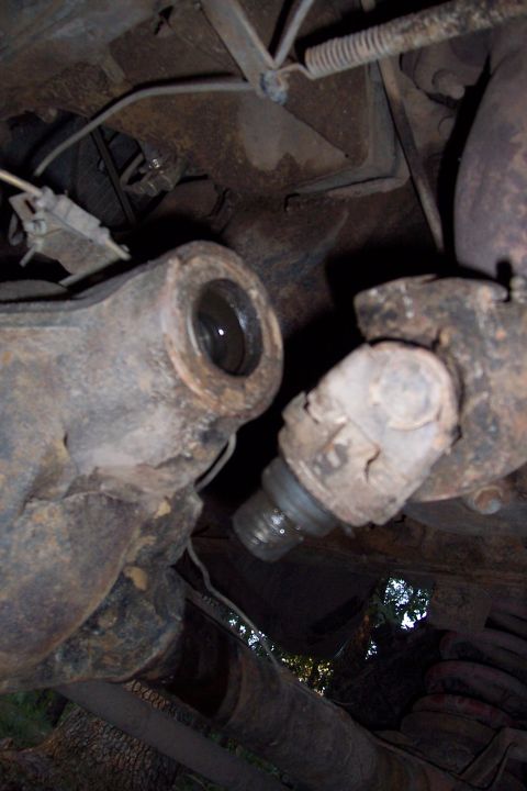 1987 Ford Bronco - Close-up view of worn suspension parts on a vehicle's undercarriage.