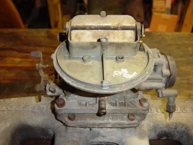 Close-up of a Holley carburetor, possibly for a classic car. It's mounted on a surface