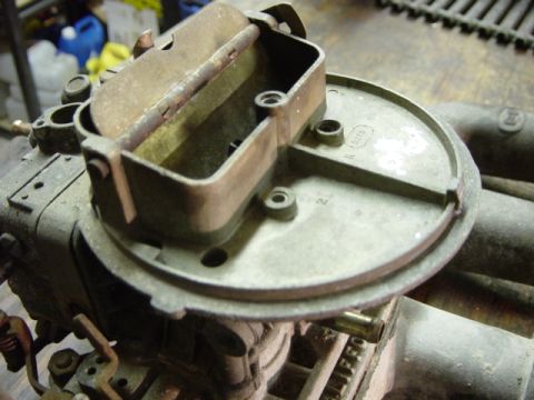 1991 Ford Bronco - Close-up of a carburetor, showing internal components and metal linkage. The registry label for a 1991 Ford Bronco is likely incorrect.