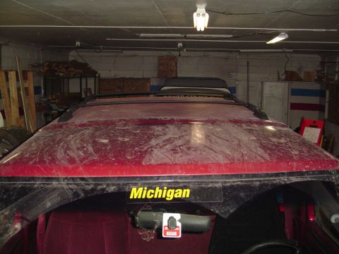 1994 Ford Bronco - Rear view of a red SUV with a 'Michigan' sticker on the back window.