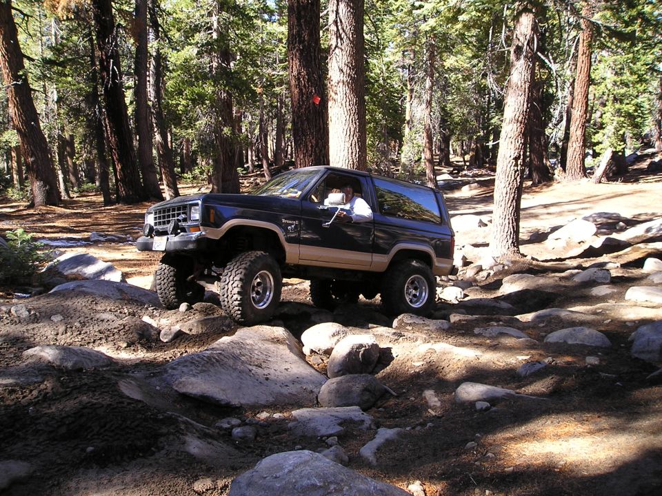 1986 Ford Bronco II navigating a rocky forest trail