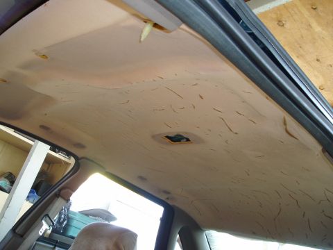 1995 Ford Taurus - The interior headliner of a car shows signs of wear with peeling fabric and exposed support structures.