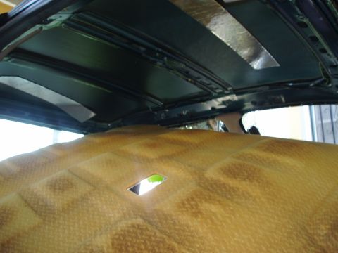 1995 Ford Taurus - The interior of a vehicle shows the headliner removed, revealing the roof structure and insulation material.