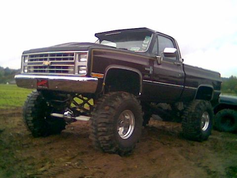 1976 GMC C/K Pickup - This lifted pickup truck has oversized tires and chrome wheels, modified for off-road use.