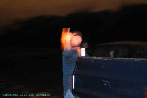 1976 GMC C/K Pickup - A person stands next to the bed of a dark pickup truck in a nighttime scene. The registry claims it is a 1976 GMC C/K Pickup, but this is n…