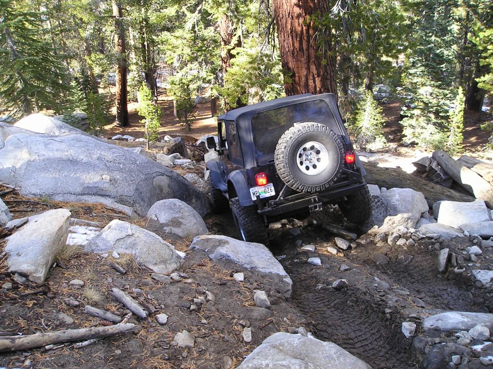 Black Jeep Wrangler TJ navigating rocky terrain