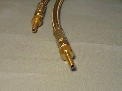 2000 Ford Excursion - Close-up view of braided hoses with brass fittings, likely for a vehicle's fluid or air system.