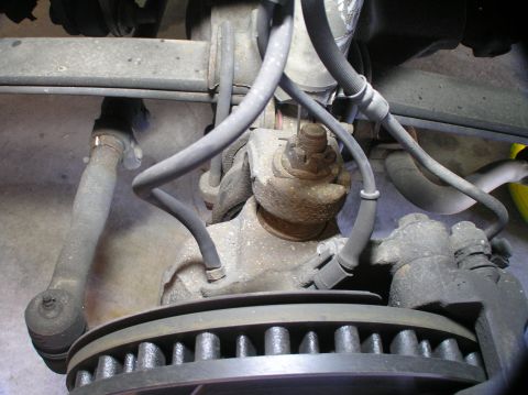 2000 Ford Excursion - Underside view of a vehicle's front wheel assembly, highlighting the brake system and steering linkage.
