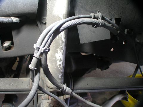 2000 Ford Excursion - Close-up view of braided brake lines and suspension components.