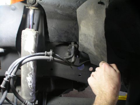 2000 Ford Excursion - Underneath view of a vehicle's front suspension system, showing shock and brake lines.