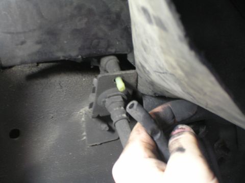 2000 Ford Excursion - A hand holds braided lines near a yellow fitting, likely part of a vehicle's ESOF/4x4 system.