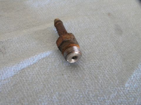 2000 Ford Excursion - Close-up of a corroded metal fitting with a threaded base and a barbed end for hose attachment.