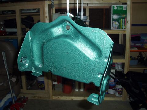 1995 Ford Taurus - A freshly painted metal bracket hangs in a garage, ready for installation.