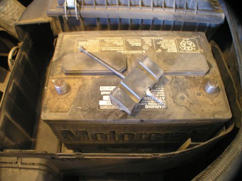 2000 Ford Excursion - Close-up of a car battery, likely a Motorcraft brand, situated within its compartment.
