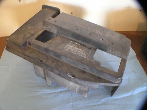 2000 Ford Excursion - A dusty black plastic battery tray is shown from an angled perspective.